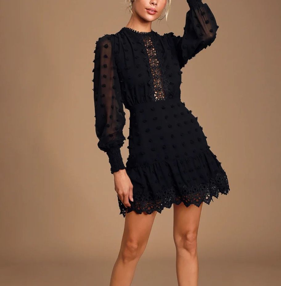 a model wearing a black embroidered lace mini dress