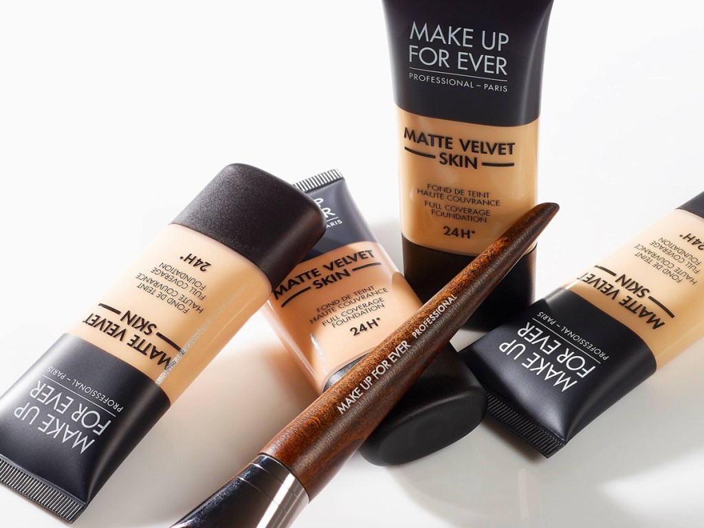 four tubes of MAKE UP FOR EVER Matte Velvet Skin Full Coverage Foundation with makeup brush