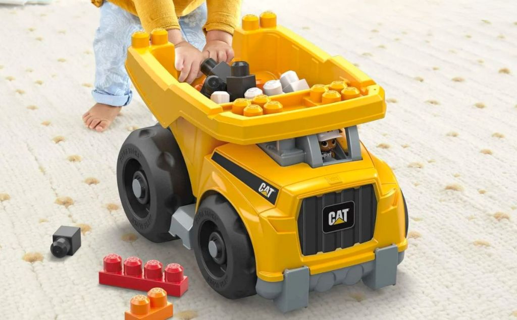 a toddlers hands playing with a MEGA BLOKS Fisher-Price Building Toy Blocks Cat Large dump truck