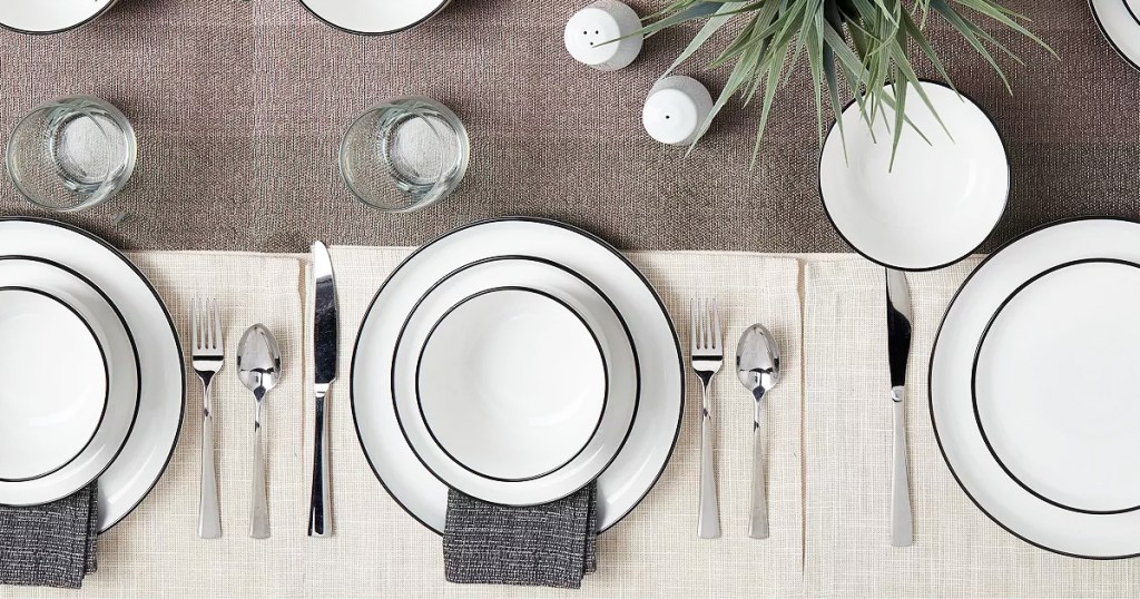 white dishes with black rims on set dinner table