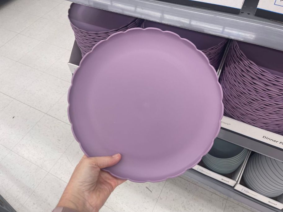 hand holding purple scalloped plastic plate