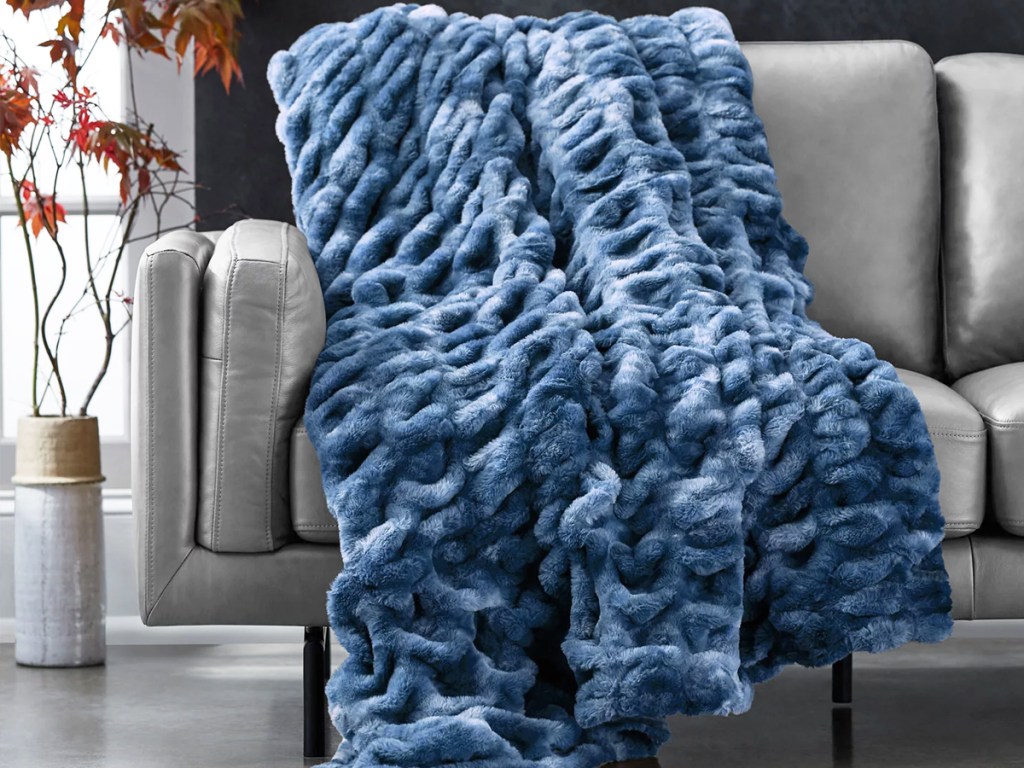 blue faux fur blanket draped over grey couch