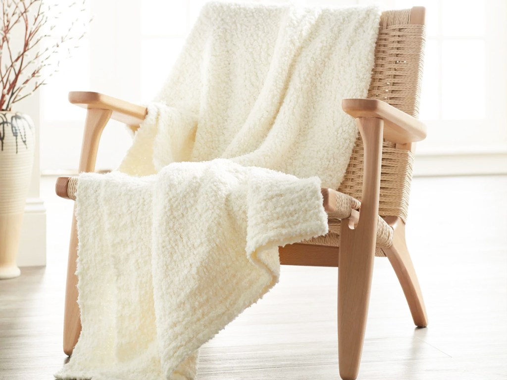 white throw blanket draped over a wood accent chair