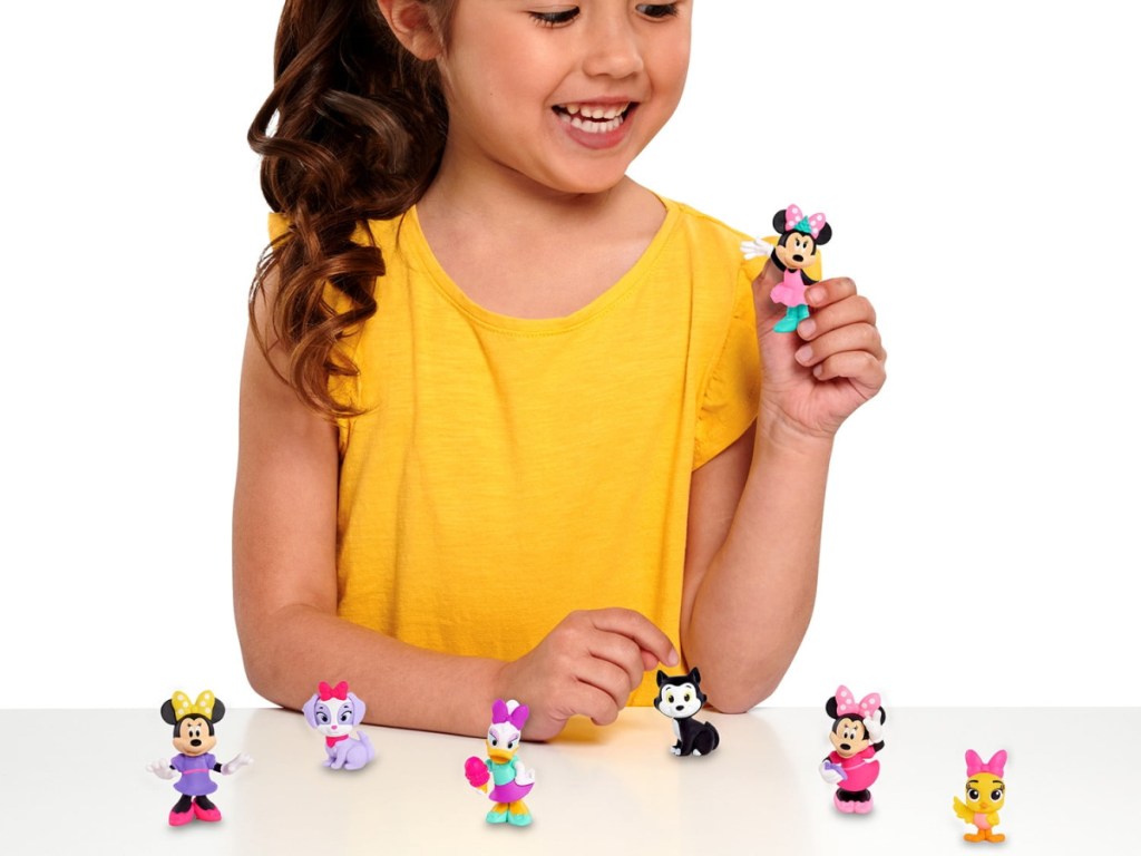 girl holding up Minnie Mouse Collectible Figures