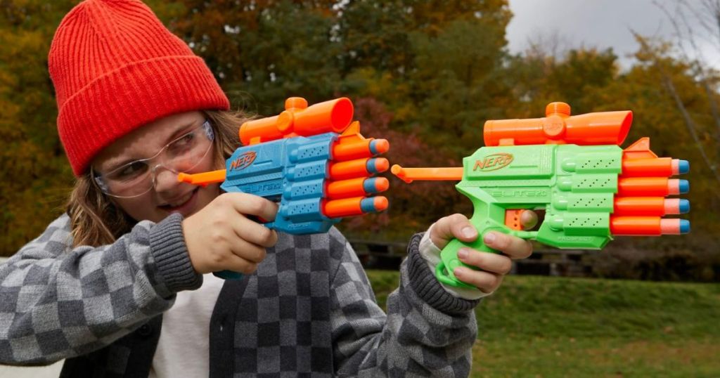 A child playing with 2 Nerf guns