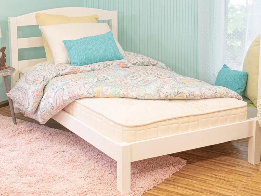 twin size mattress on a white bed frame in a kids room