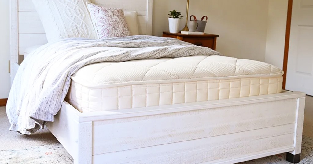 white mattress on a white bed frame in a bedroom