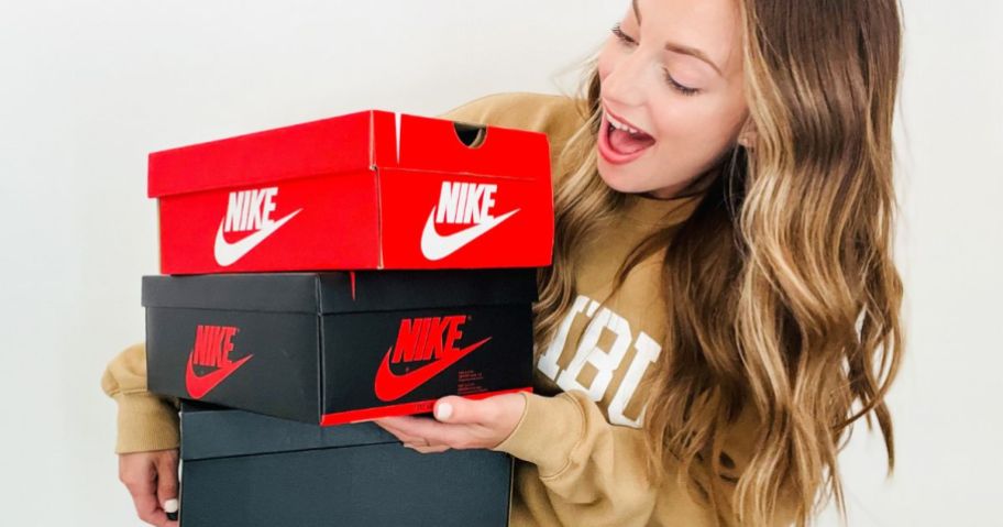 Woman with very excited look on her face holding Nike Shoe boxes