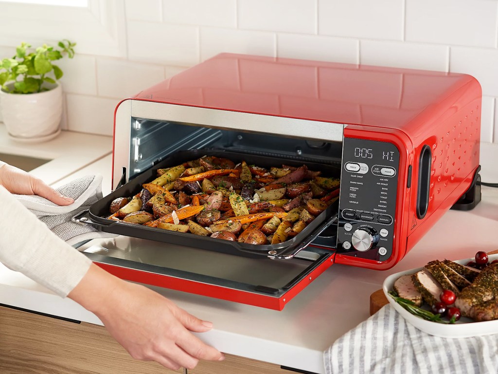removing sheet of roasted vegetables from red ninja foodi oven