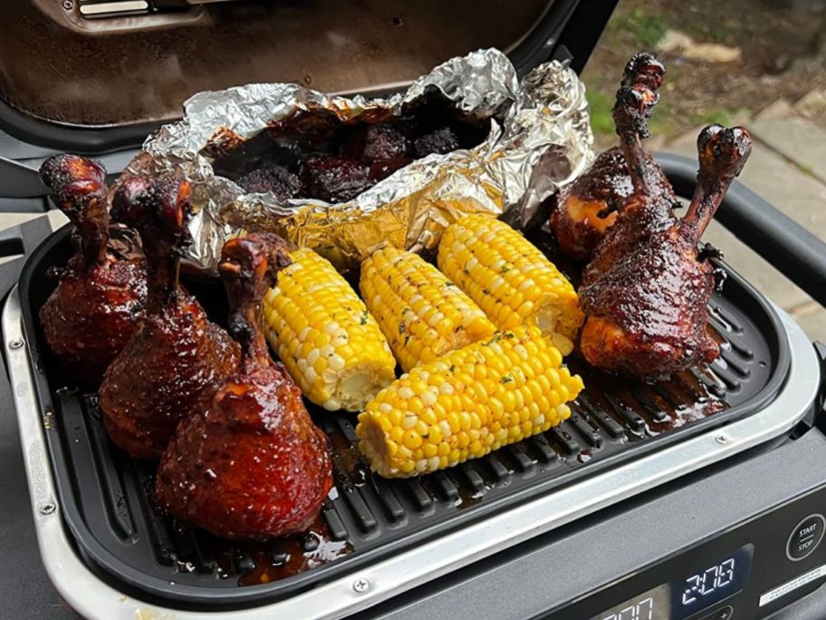 AQ Ninja Woodfire Grill with meats and corn on it