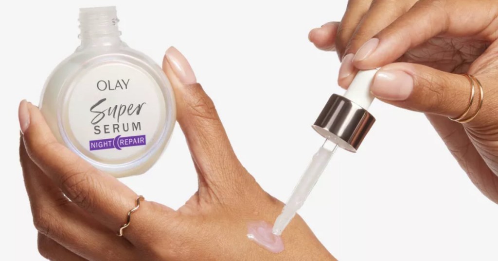 woman putting drop of Olay Super Serum Night Repair on her hand