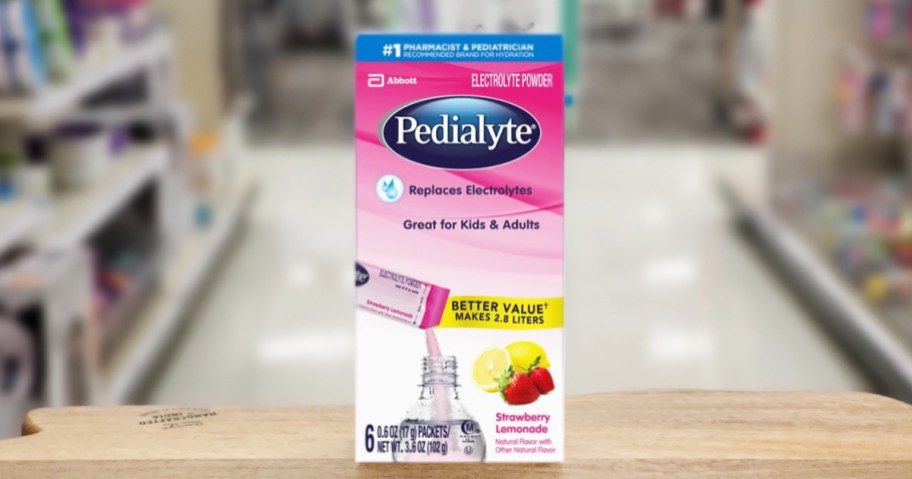 pink box of Pedialyte Electrolyte Powder Packets on wood table in store