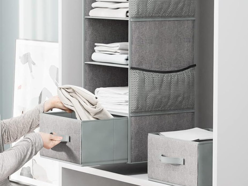 placing clothing into drawer of hanging closet organizer