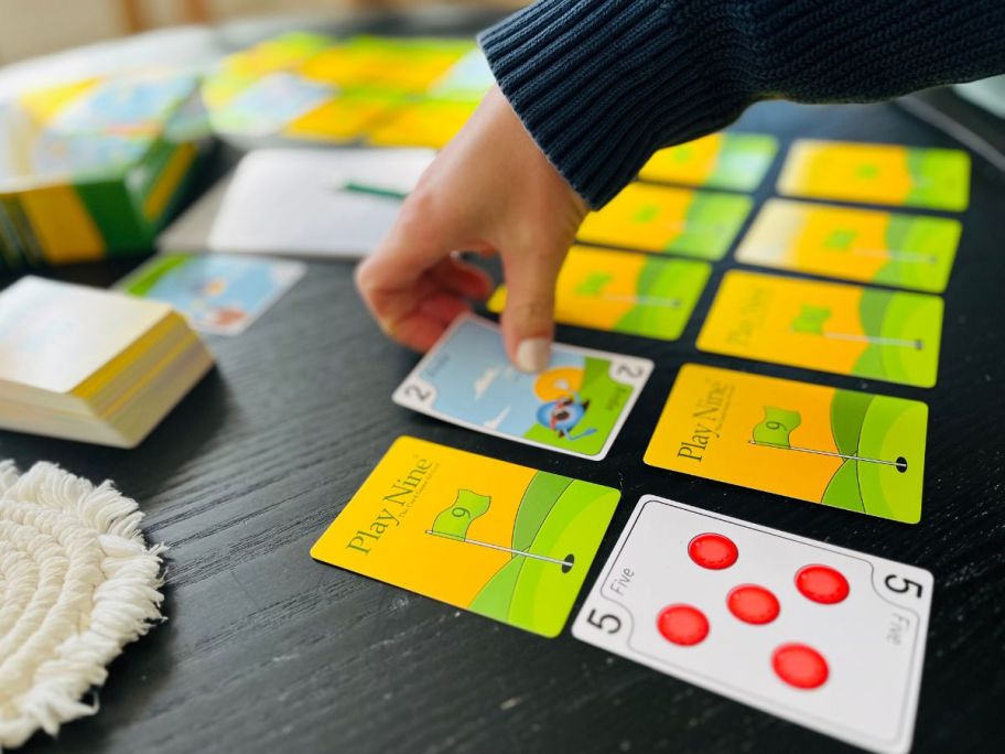 hand flipping play nine cards on coffee table