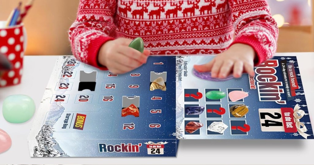 kid opening doors on Rock Advent Calendar on table