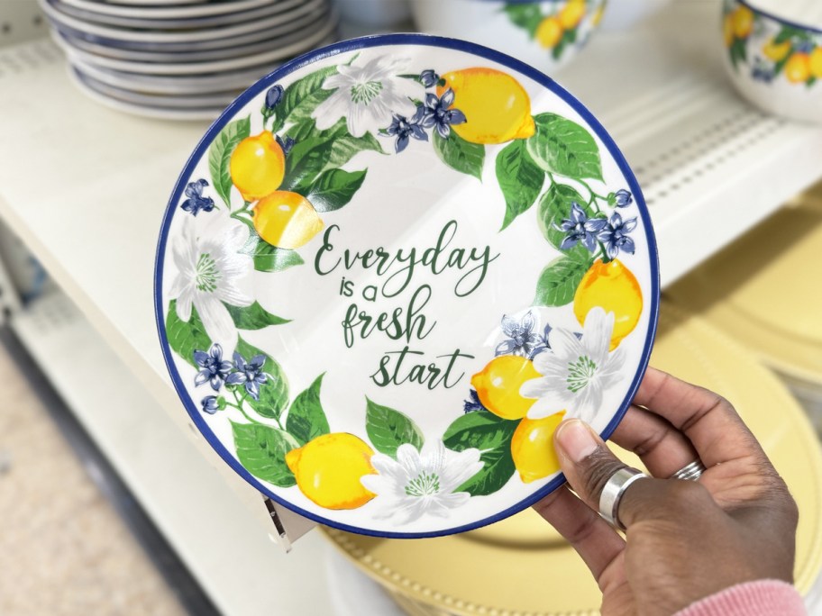 hand holding up a lemon print plate that says "everyday is a fresh start"