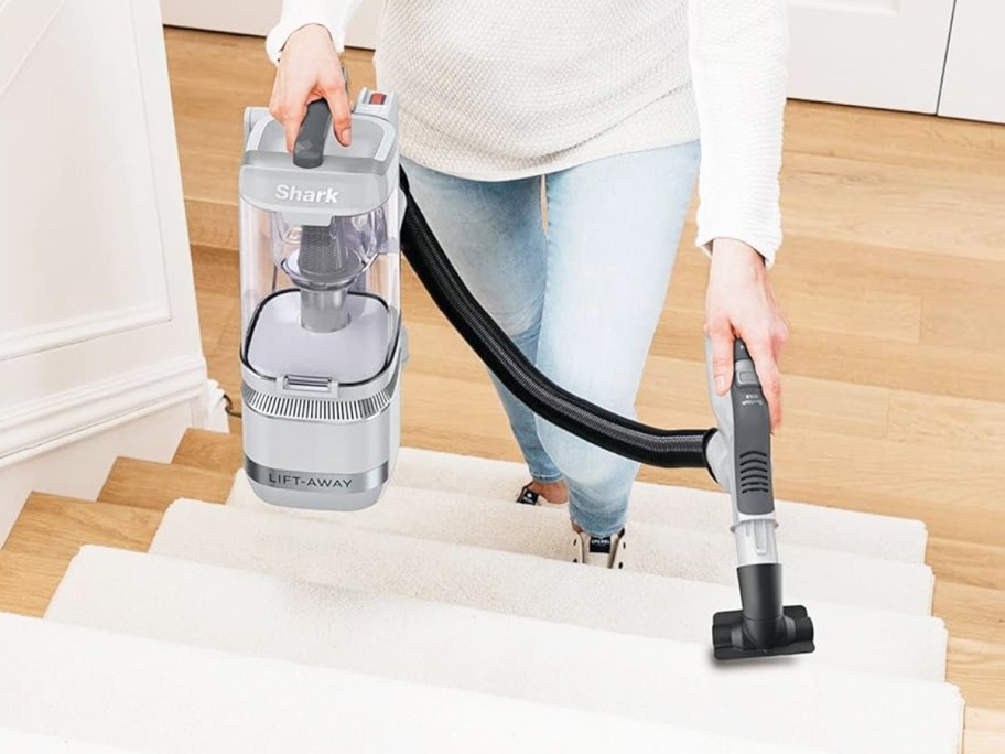 woman cleaning stairs with shark lift away vacuum