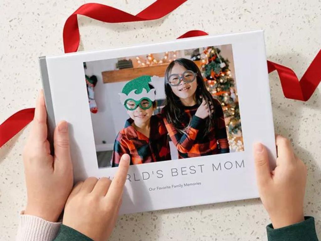 A shutterfly photo book with kids hands holding it