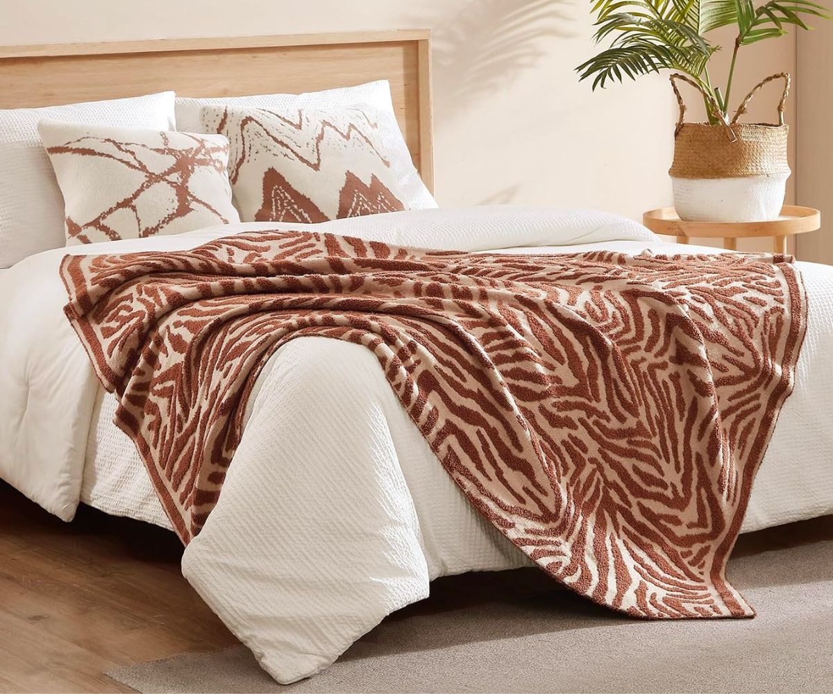 Snuggle Sac Luxury Feather Yarn Fluffy Throw Blanket 50x60 in Brown Zebra draped across a bed