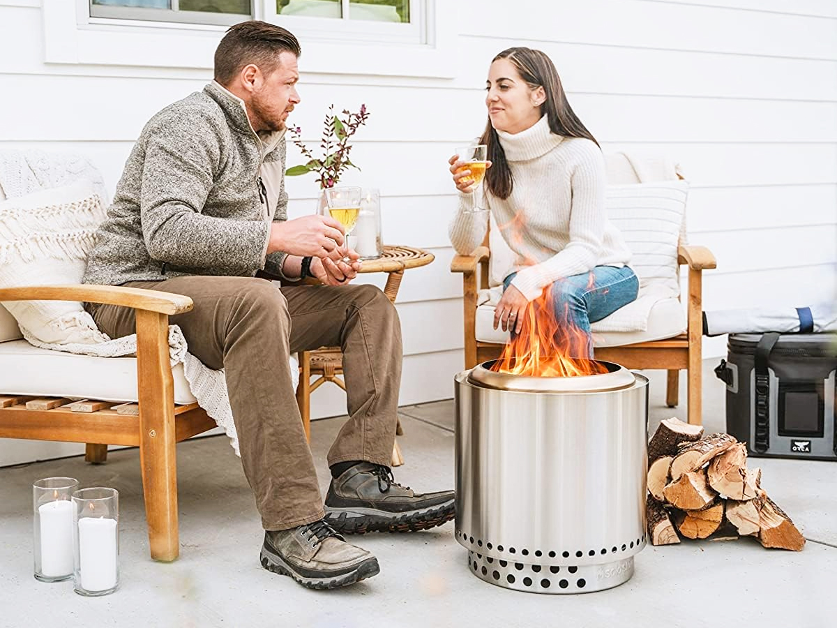 couple drinking wine near fire pit