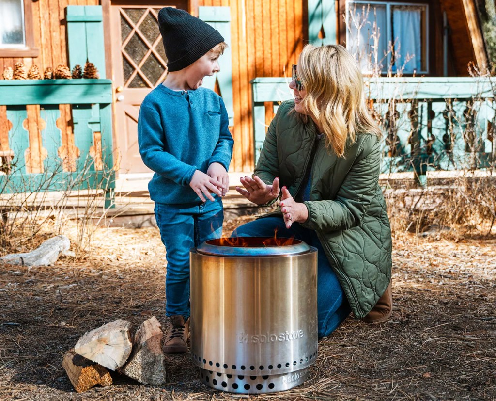 mom and son standing next to fire pit