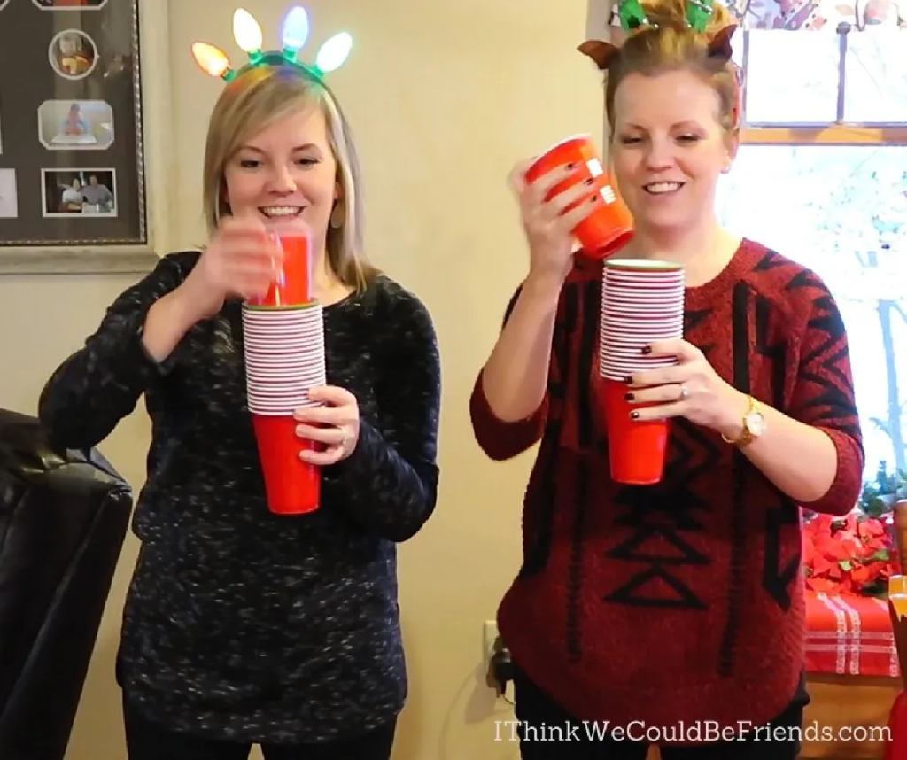 Two women playing Stack Off with cups, a favorite of the Christmas party games