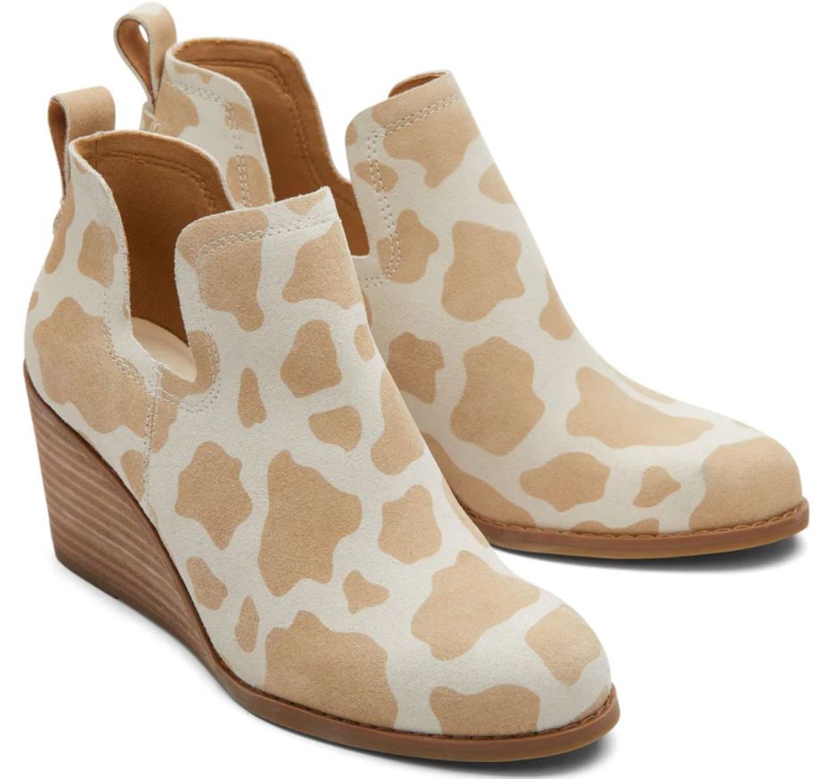 a pair of cow print wedge booties