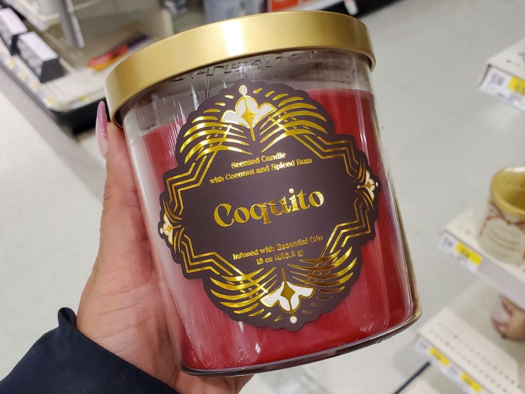 Hand holding a Coquito candle from Target