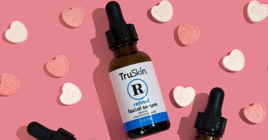 bottle of TruSkin Retinol Serum with candy hearts around it