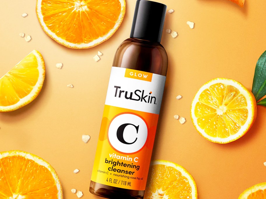 bottle of TruSkin Vitamin C Facial Cleanser near sliced oranges
