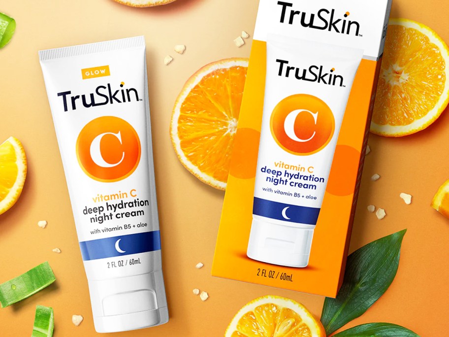 bottle and box of TruSkin Vitamin C Night Cream near sliced oranges