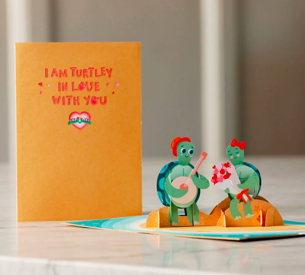 Turtley in Love Pop-Up Card open on a marble table top