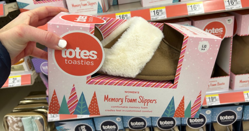 Person holding tan colored totes memory foam slipper at Walgreen store