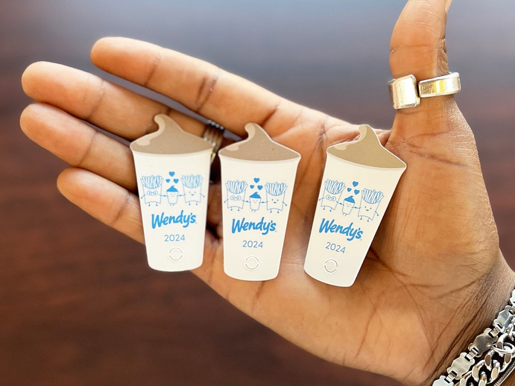 three Wendy's frosty key tags in palm of hand