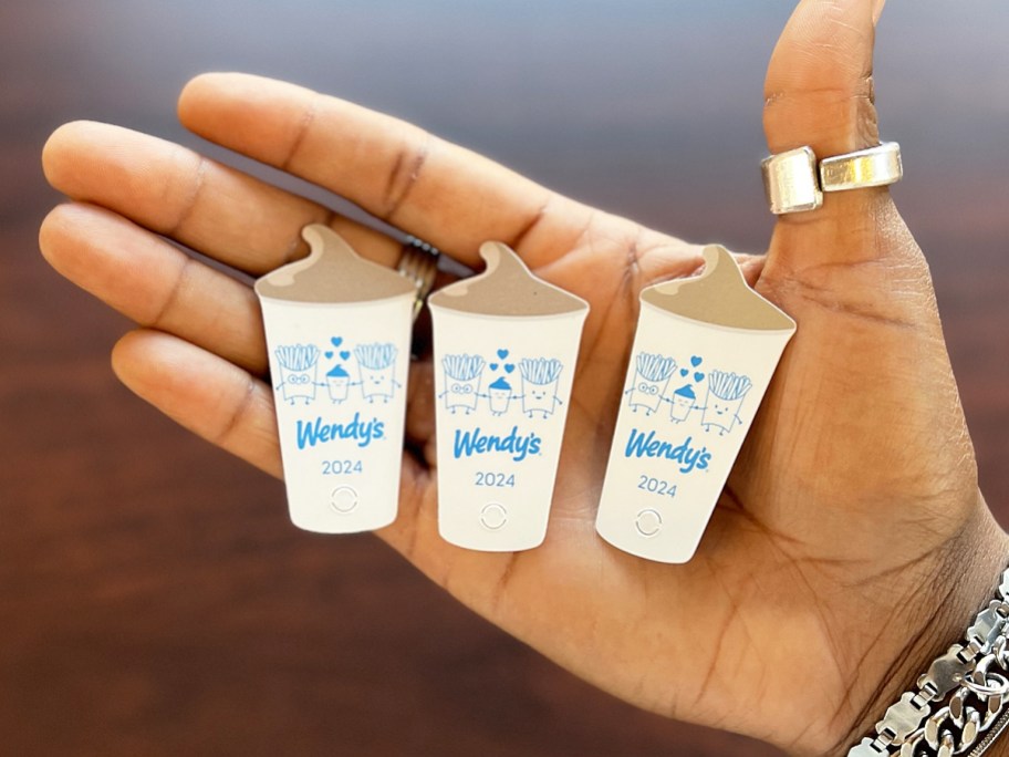 three Wendy's frosty key tags in palm of hand