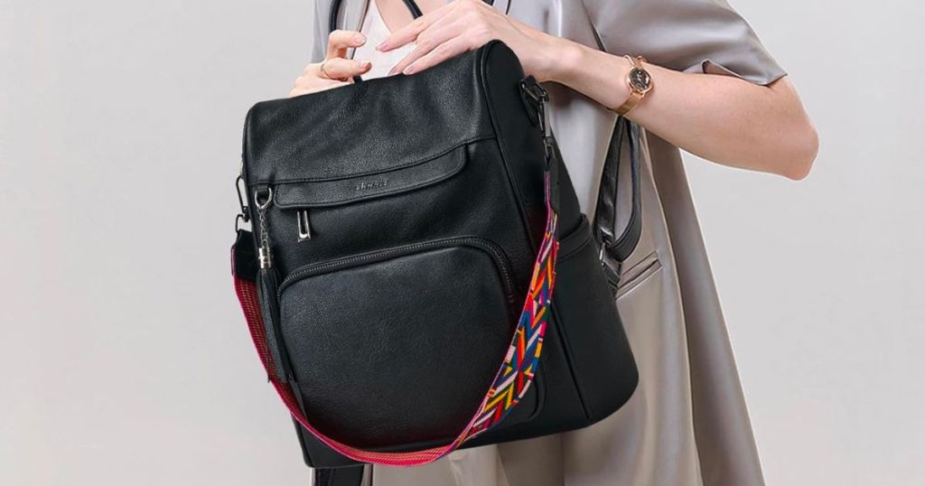 a model holding a Women’s Anti-Theft Travel Backpack in black