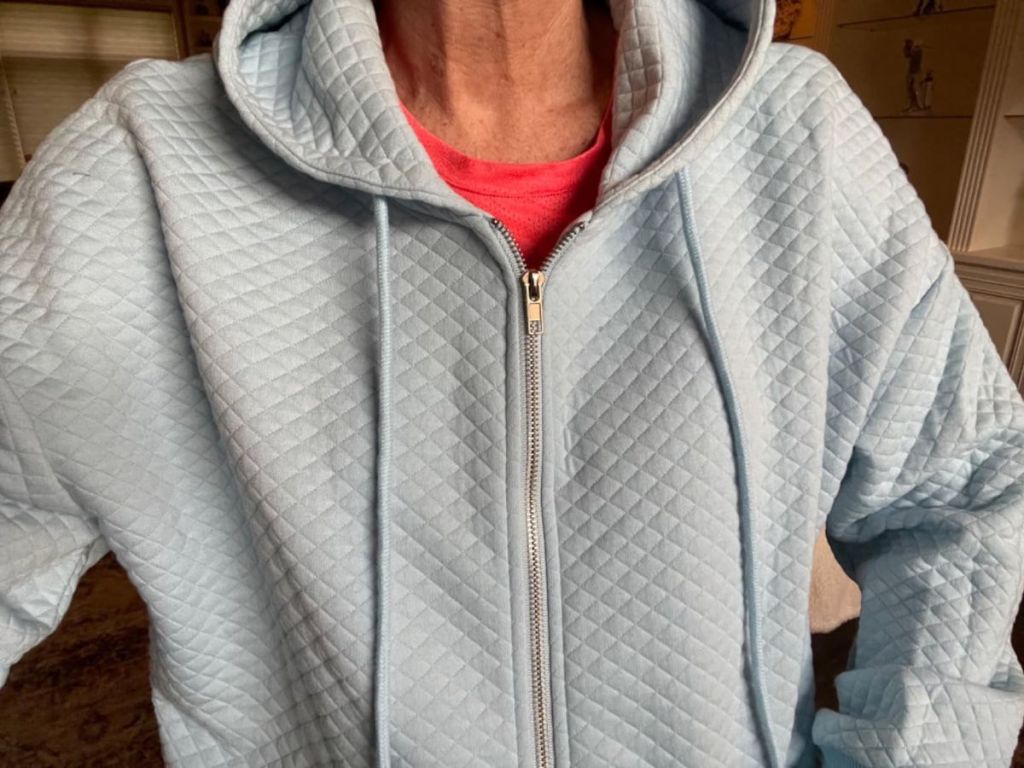 Close up view of a woman wearing a merokeety full zip quilted hoodie