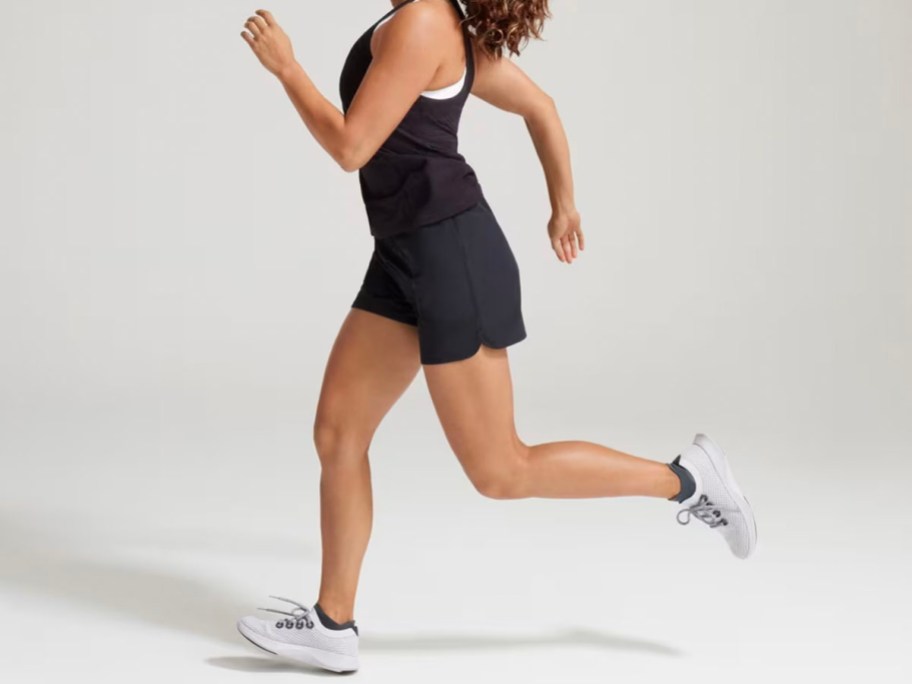 woman running wearing black allbirds shorts and tee