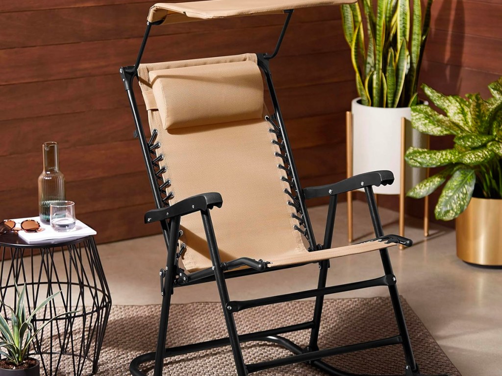 tan folding rocking chair with canopy on porch
