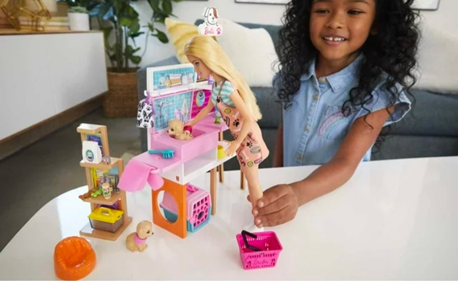girl playing with barbie pet boutique playset