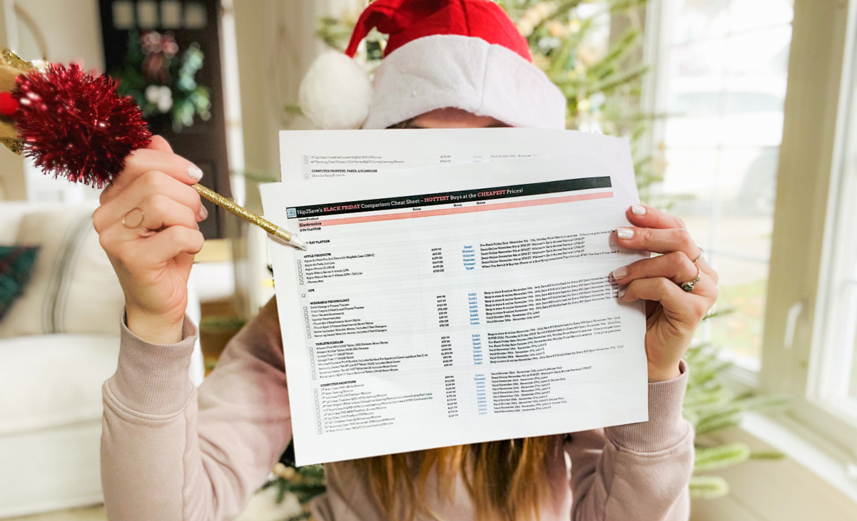 woman in a santa hat holding up a printed tracker and pointing at it