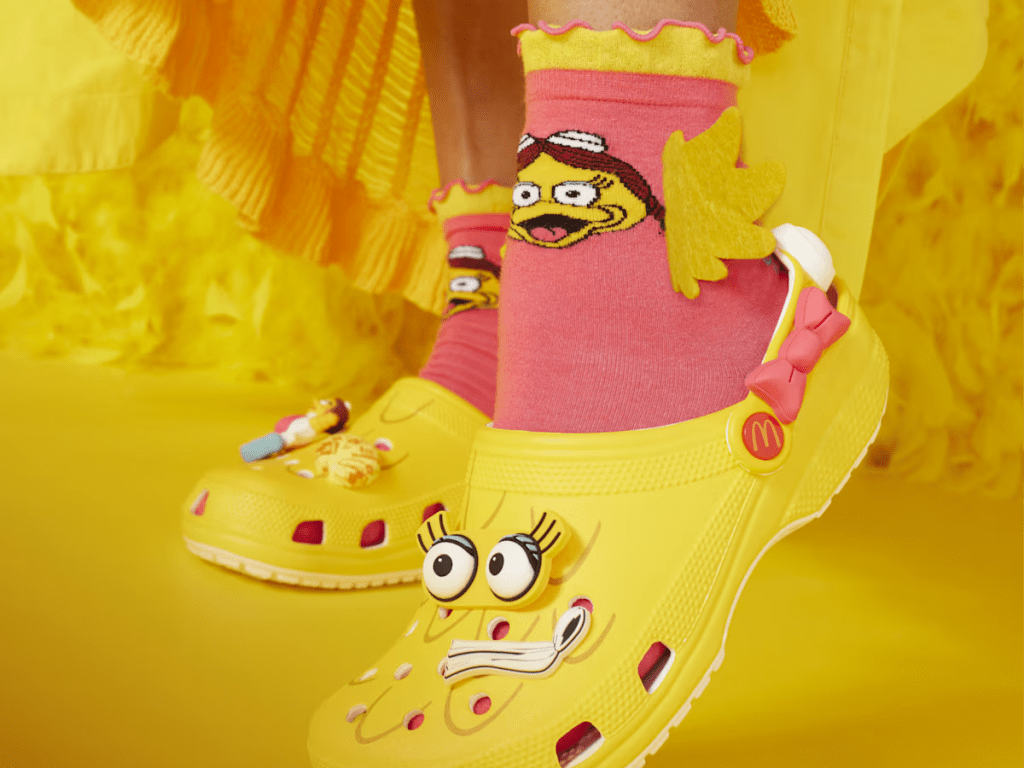 feet wearing yellow Birdie Crocs and socks