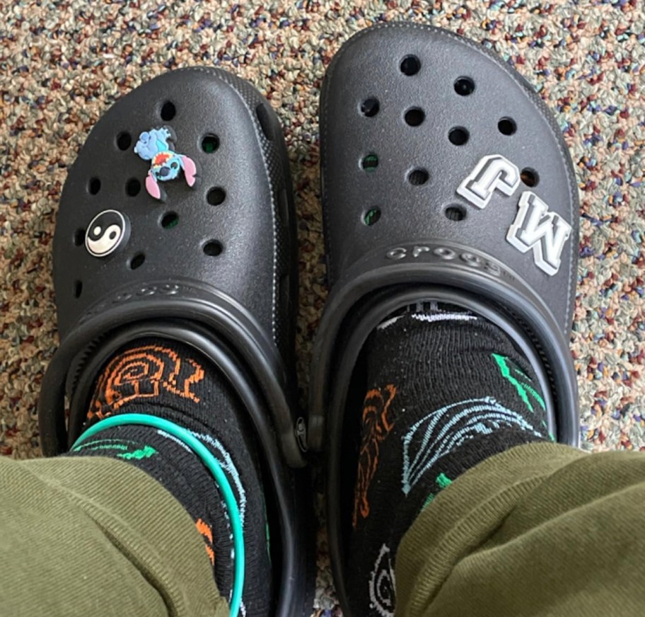 close up of feet wearing black crocs with socks