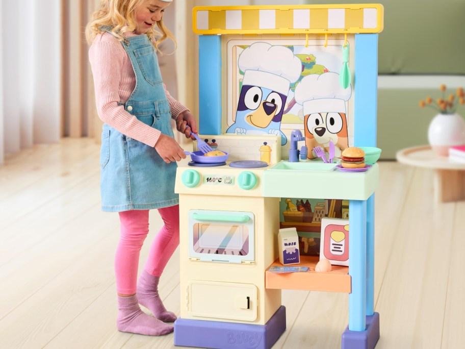 girl playing with a Bluey toy Kitchen