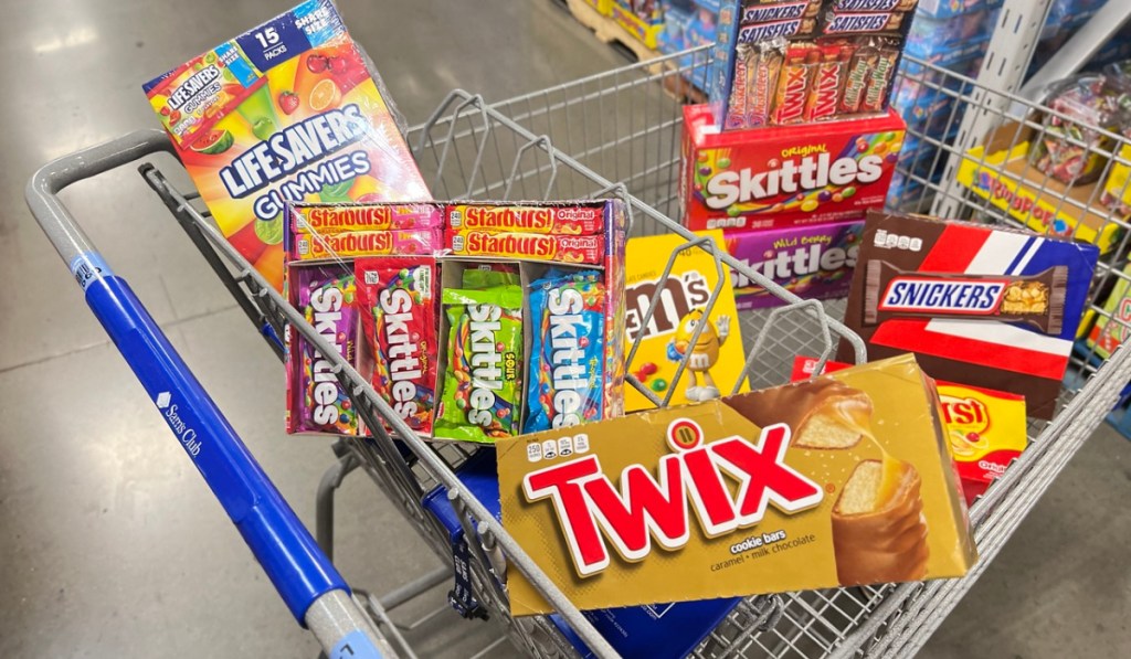 various candy boxes in a sam's club cart