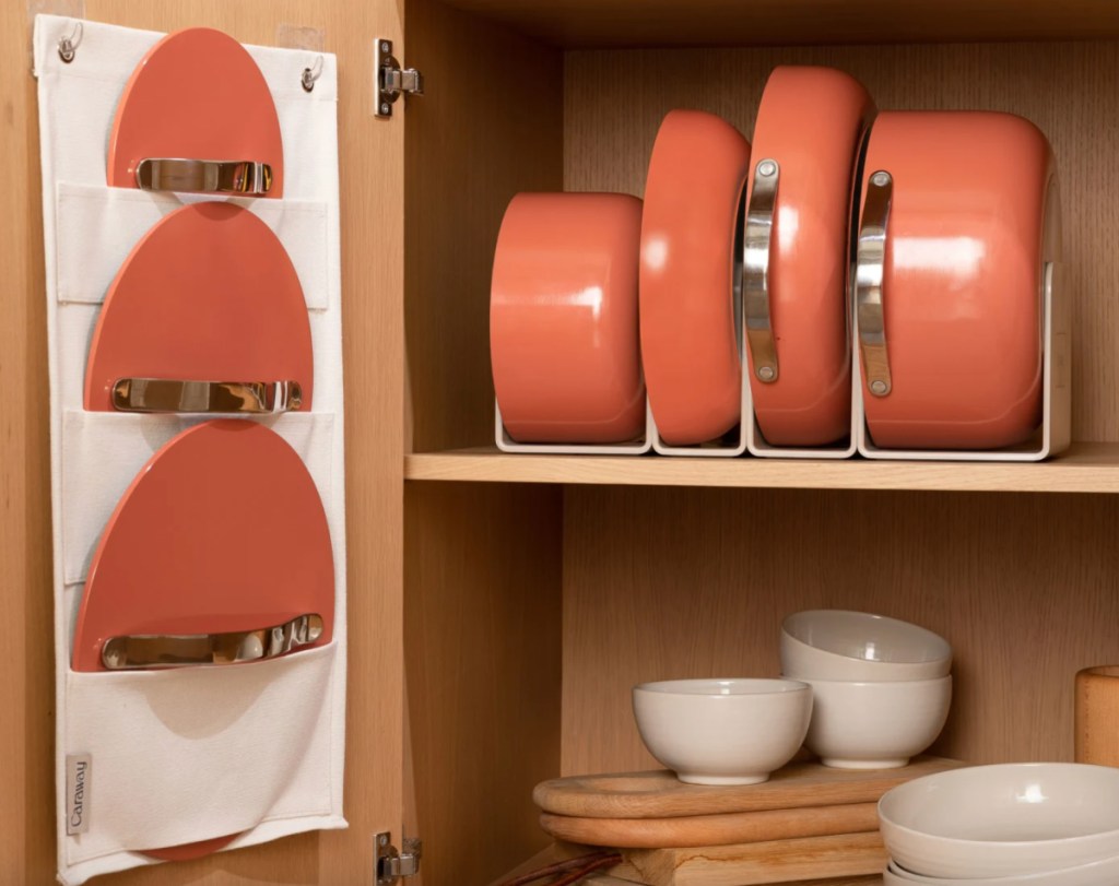 salmon pink colored pots and pans inside cabinet