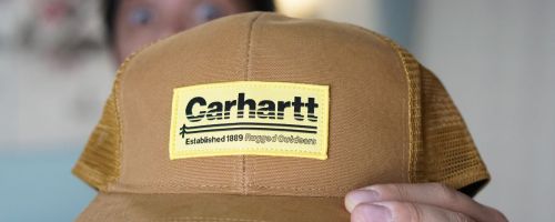 A man holding a Carhartt hat