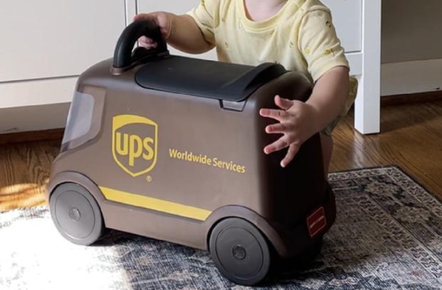 child holding UPS ride on cart