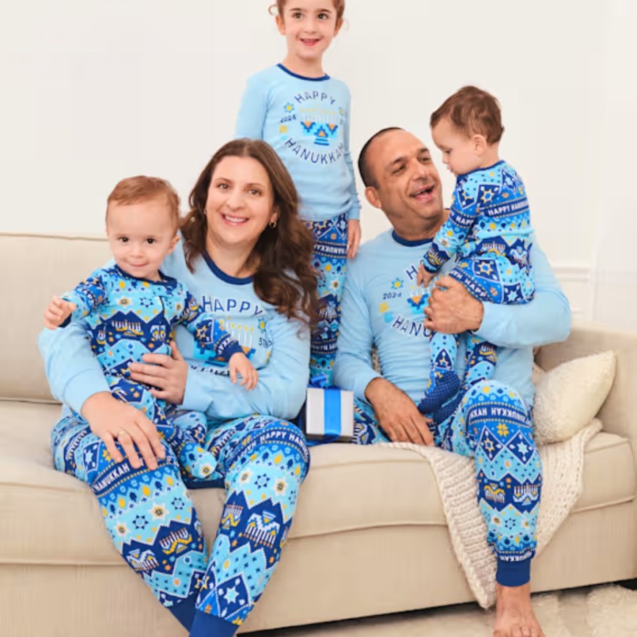 family wearing matching blue Christmas Pajamas that say 