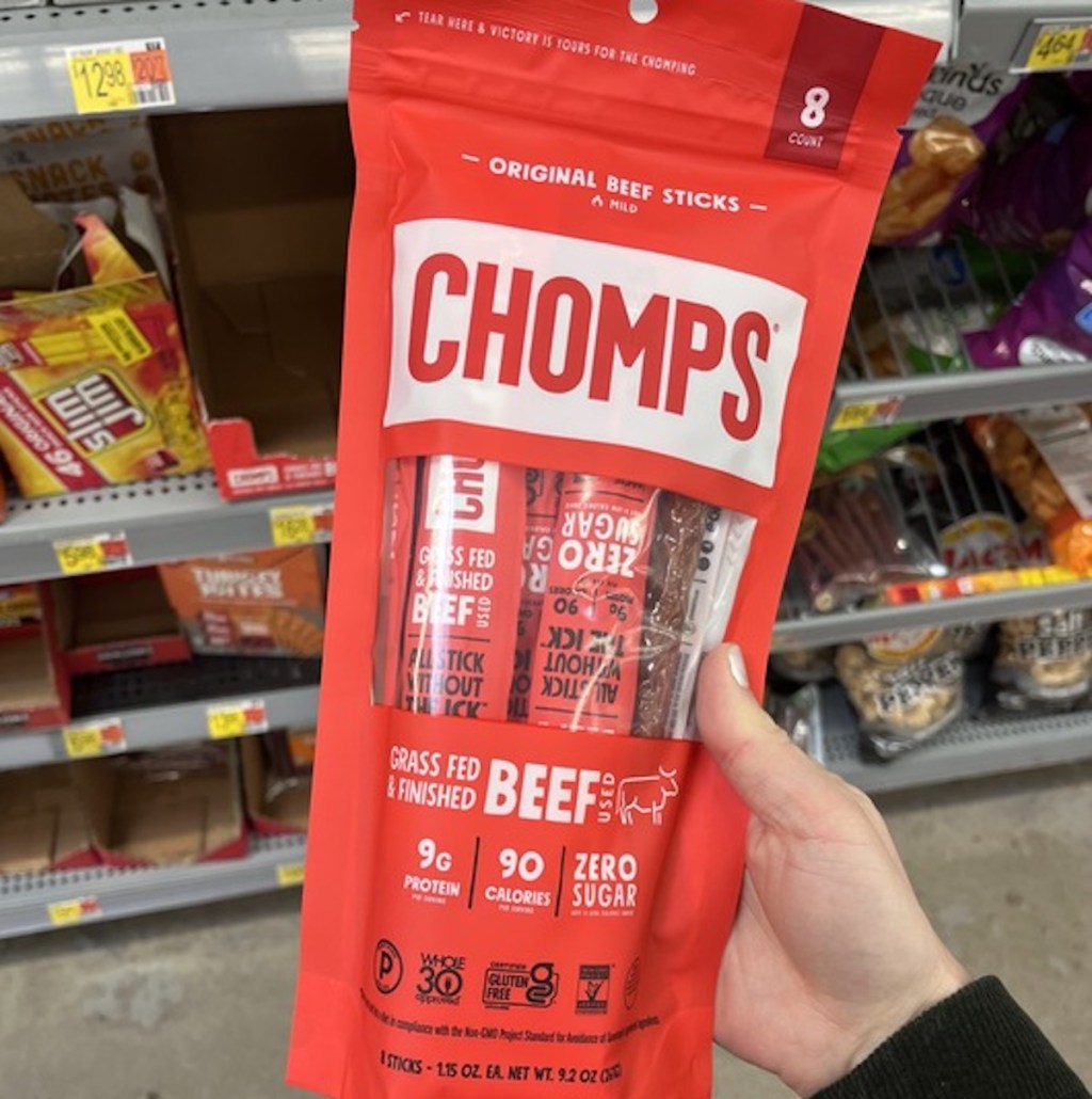 hand holding a pack of red chomps beef jerky sticks in store aisle